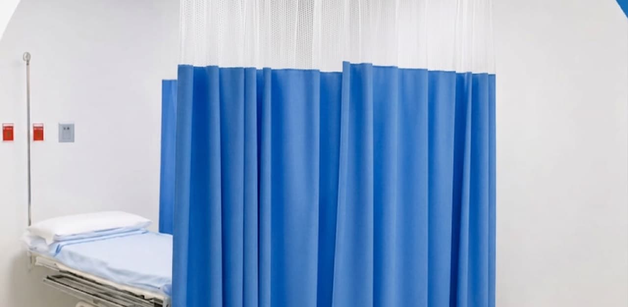 Cubículo hospitalario formado con cortinas azules MEDIVANG sobre riel